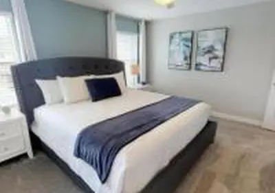 a bedroom with a large bed with a blue blanket at 4826 LL - Storey Lake Dream 4BR Pool Home Near Disney in Kissimmee