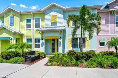 a row of colorful houses with palm trees at Blue Sky Hideaway Villa Near Disney With Margaritaville Resort & Island H20 Waterpark Access - 2921Cs in Orlando