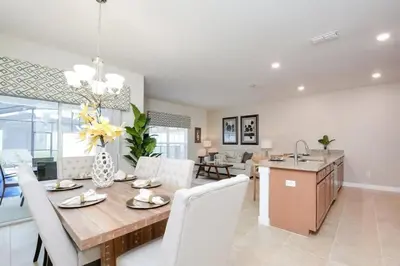 a dining room and living room with a table and chairs at 4815 Townhome com Piscina Privada– Storey Lake in Kissimmee
