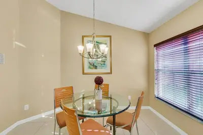 a dining room with a glass table and chairs at Private Pool Villa, 3mi to Disney with Game Room in Kissimmee