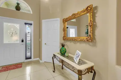 a room with a table and a mirror on the wall at Private Pool Villa, 3mi to Disney with Game Room in Kissimmee