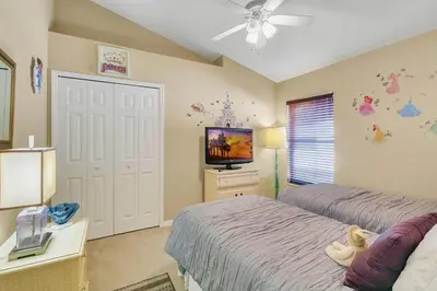 a bedroom with two beds and a flat screen tv at Private Pool Villa, 3mi to Disney with Game Room in Kissimmee