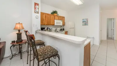 a kitchen with a counter and two chairs at OP7652 Windsor Hills 3 Bedroom Private Pool Townhome in Orlando
