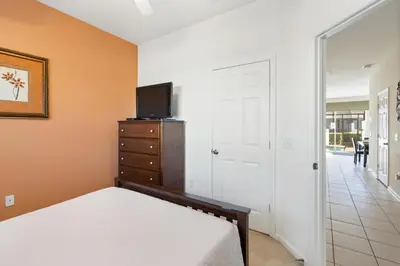 a bedroom with a bed and a tv on a dresser at OP7678 Windsor Hills 3 Bedroom Private Pool Townhome in Orlando