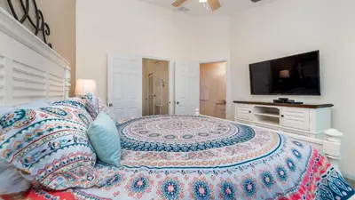 a bedroom with a large bed and a flat screen tv at RS2508 Windsor Hills Resort 3 Bedroom Private Pool Townhome in Orlando