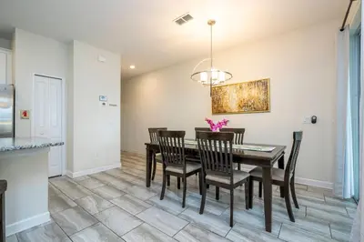 a dining room with a table and chairs at Storey Lake 4 BR with private pool in Kissimmee