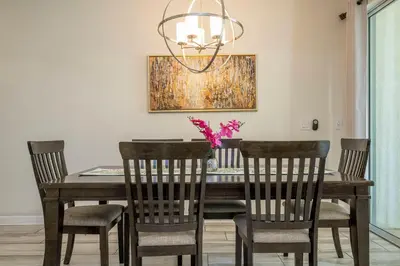a dining room table with chairs and a chandelier at Storey Lake 4 BR with private pool in Kissimmee