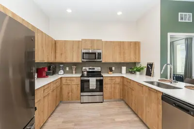 a kitchen with wooden cabinets and a stove top oven at Orlando 2BR Mins to Universal and More in Orlando