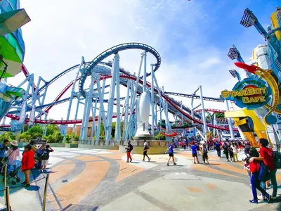 a roller coaster in a amusement park with a crowd of people at Orlando 2BR Mins to Universal and More in Orlando