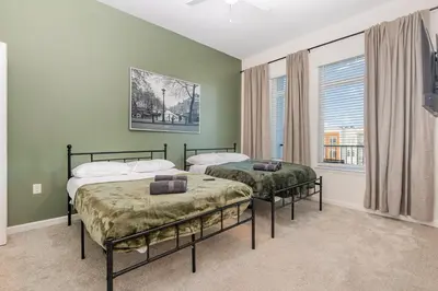 two beds in a room with green walls and windows at Orlando 2BR Retreat 3 Beds Near Disney&Universal in Orlando