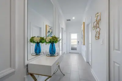 a hallway with two blue vases with flowers in it at Casa 5Q c/ Piscina e Temas Disney — Storey Lake in Kissimmee