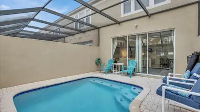 a swimming pool with two chairs and a table at SKC7679 Windsor Hills Resort Vacation Townhome - includes resort clubhouse amenity access in Orlando