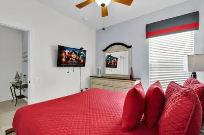 a bedroom with a red bed with red pillows and a mirror at MNL2702 Windsor Hills Resort Vacation Home - includes resort clubhouse amenity access in Orlando