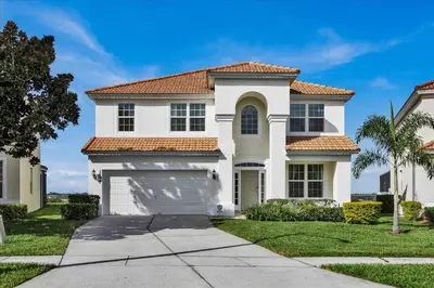 a white house with a garage at AF2574 Windsor Hills Resort Vacation Home - includes resort clubhouse amenity access in Orlando
