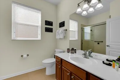 a bathroom with a sink and a toilet and a mirror at AF2574-Windsor Hills Resort Vacation Home in Orlando