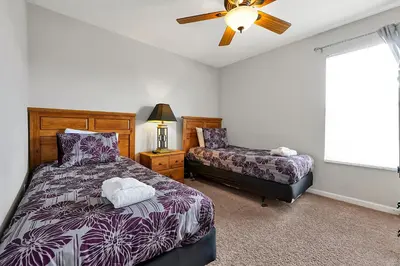 a bedroom with a bed and a window with a fan at Windsor Palms Resort in Kissimmee