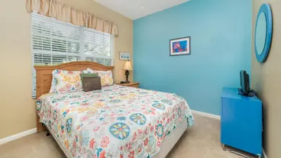 a blue bedroom with a bed and a window at Windsor Palms Resort in Kissimmee