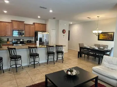 a kitchen and living room with a table and chairs at Casa 4 Quartos c/ Piscina Privativa – Storey Lake in Kissimmee