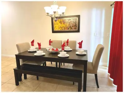 a dining room table and chairs with red cards on it at Casa 4 Quartos c/ Piscina Privativa – Storey Lake in Kissimmee