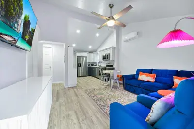 a living room with a blue couch and a ceiling fan at Cozy 2bd 2bth House Walk to Local Gems in Orlando
