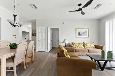 a living room with a couch and a table at 3BR Resort Condo Pool Balcony Near Disney in Kissimmee