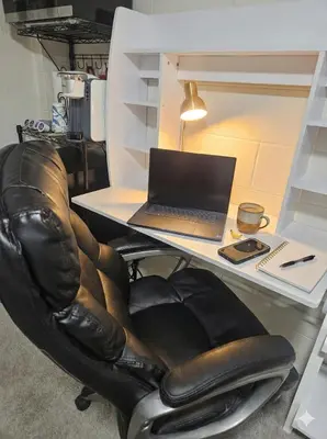 a laptop computer sitting on a desk with a leather chair at Sanford Suite King Bed Work-Ready Near Beach MCO in Sanford