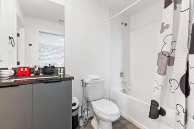 a white bathroom with a toilet and a shower at 8740 Enchanted Stay near Disney in Kissimmee