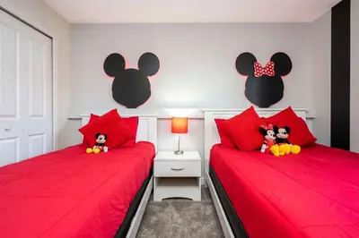 two beds with red pillows with stuffed mice on them at Refúgio 4Q com Piscina em Storey Lake in Kissimmee