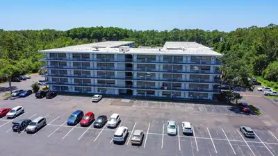 a large building with cars parked in a parking lot at Aqua Azul Oasis in Kissimmee-minutes from Disney in Kissimmee