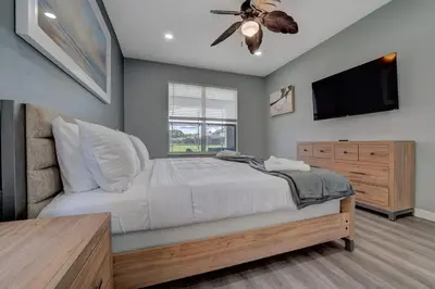a bedroom with a bed with a ceiling fan and a television at Terra Verde Lakeview Escape in Kissimmee