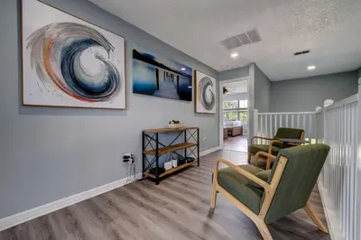 a living room with two chairs and a painting on the wall at Terra Verde Lakeview Escape in Kissimmee