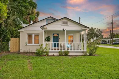 a small white house with a porch in a yard at Winter Park Gem 2BR Near Parks 3MI to Downtown in Orlando