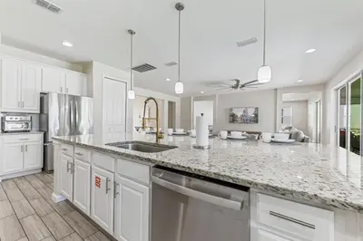 a kitchen with white cabinets and a granite counter top at 2605 Yountville Ave in Kissimmee