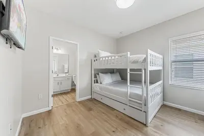 a white bedroom with a bunk bed and a mirror at 2605 Yountville Ave in Kissimmee