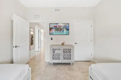 a white room with two beds and a radiator at 3141 Paradox Circle 101 in Kissimmee