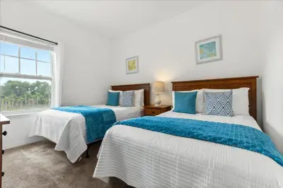 two beds in a room with a window at 4 Bedrooms 3 Bathrooms Lucaya Village 23-108 in Kissimmee