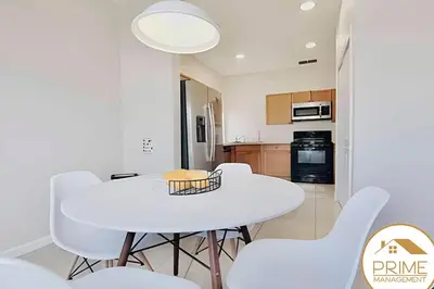 a kitchen and dining room with a white table and chairs at 4BRRenovateNO Resort feePrivate PoolDisney in Kissimmee
