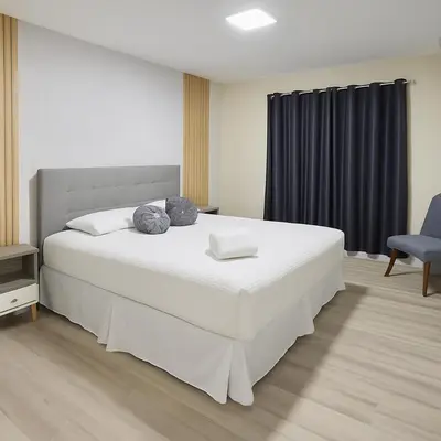 a bedroom with a large white bed and a chair at 4BRRenovateNO Resort feePrivate PoolDisney in Kissimmee