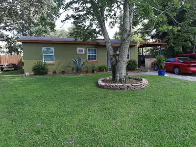 a small house with a tree in a yard at Epic Universal park neigbour 1500 feet in Orlando