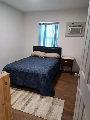a bedroom with a bed with a blue comforter and a window at Epic Universal park neigbour 1500 feet in Orlando