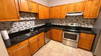 a kitchen with wooden cabinets and a stove top oven at K11 Private Room with Smart TV Near Everything in Orlando