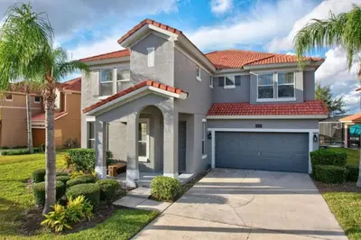a house with a garage and palm trees at 6 Bedrooms - 5,5 Bathrooms - Bella Vida 4529Ss in Kissimmee