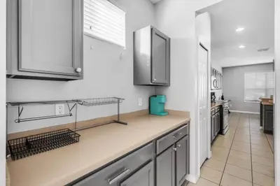 a kitchen with white walls and stainless steel appliances at 6 Bedrooms - 5,5 Bathrooms - Bella Vida 4529Ss in Kissimmee
