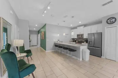 a large kitchen with green chairs and a counter at 4824 Resort Pool House Disney Universal Orlando in Kissimmee