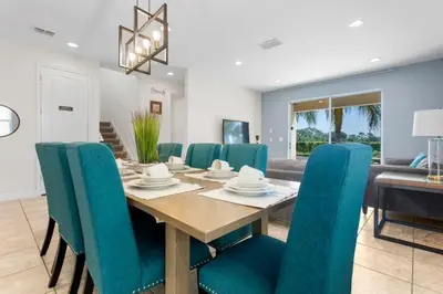 a dining room with a wooden table and blue chairs at 361 Pendant ct in Orlando