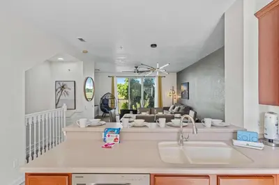 a kitchen with a sink and a living room at 8036 Spacious Fresh 3BR3.5BA at Vista Cay 133 in Orlando