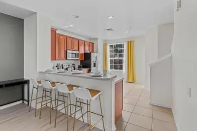 a kitchen with a counter and stools in a room at 8036 Spacious Fresh 3BR3.5BA at Vista Cay 133 in Orlando