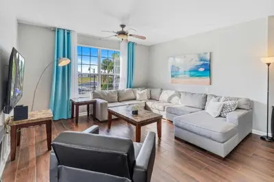 a living room with a couch and a tv at 5049 Ultimate Orlando retreat at Vista Cay 203 in Orlando