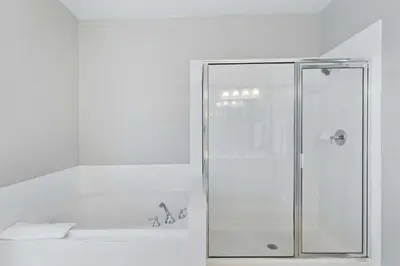 a white bathroom with a shower and a tub at 5049 Ultimate Orlando retreat at Vista Cay 203 in Orlando