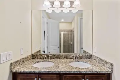 a bathroom with two sinks and a large mirror at 500 Luxurious 8BR Villa with Private PoolSpa in Orlando